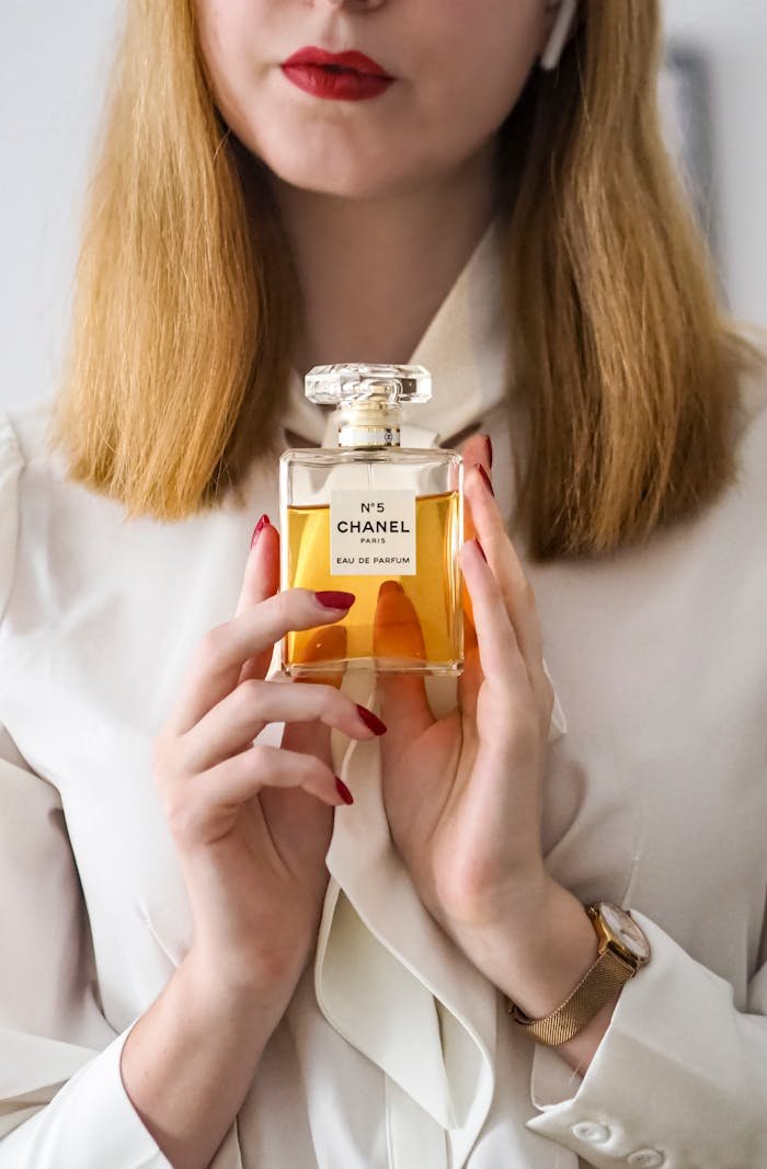 Elegant woman holding Chanel No.5 Eau de Parfum, showcasing luxury and style.