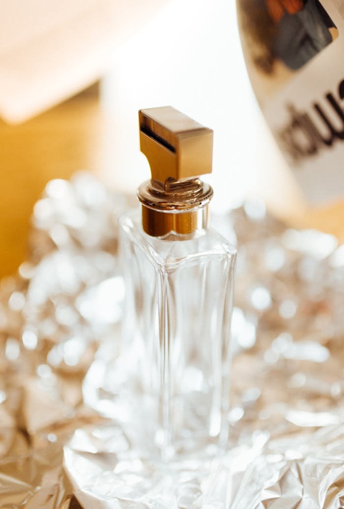 Elegant perfume bottle on shimmering surface, showcasing luxury and style.